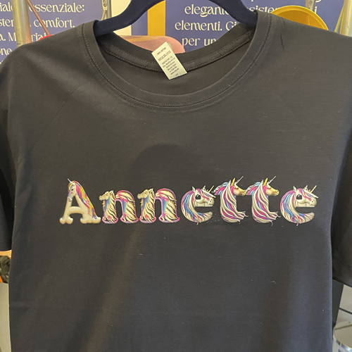 Maglietta blu con il nome Annette scritto con lettere a tema unicorno