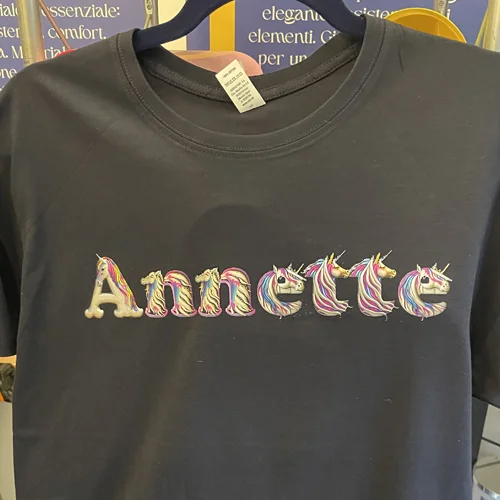 Maglietta blu con il nome Annette scritto con lettere a tema unicorno
