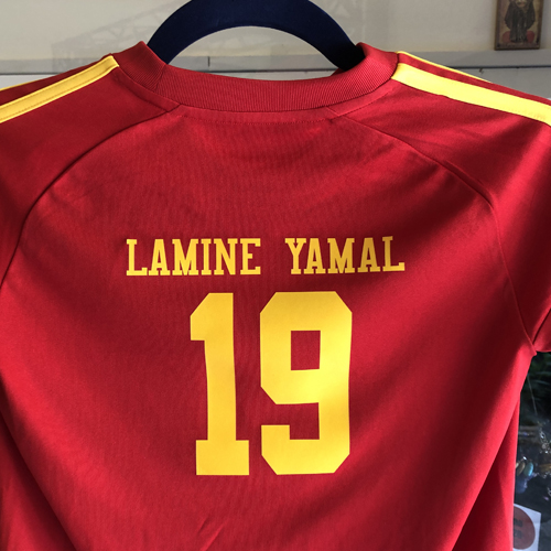 Maglia sportiva rossa con nome e numero stampati in giallo sul retro