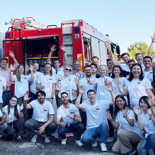 Aula con partecipanti seduti che indossano le magliette bianche personalizzate dell'evento